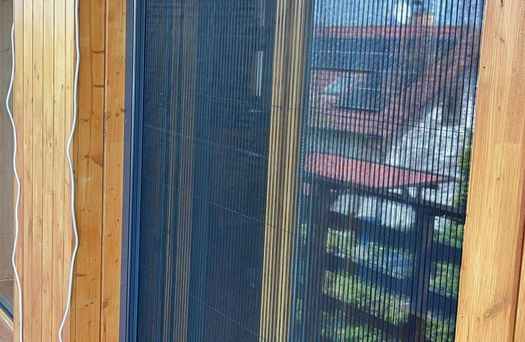 Plisovaná síť proti hmyzu v moderním hliníkovém rámu dokonale ladí s dřevěným obložením. Poskytuje spolehlivou ochranu, plynulý chod a téměř neviditelný vzhled.