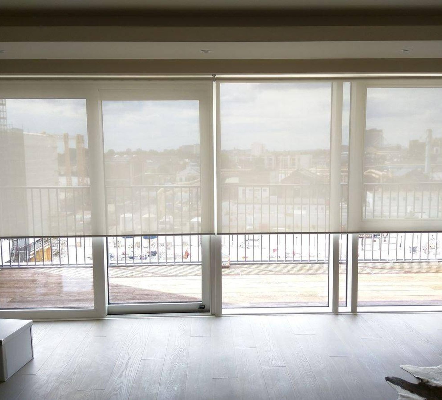 Bílé látkové rolety u balkonu