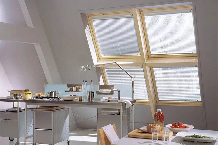 Střešní okna s žaluziemi v bílém pokoji